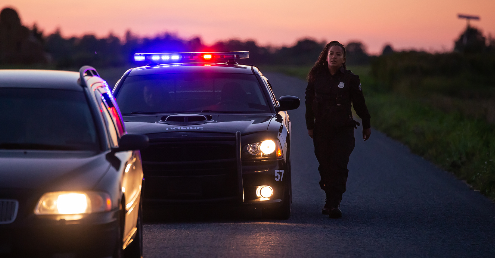 Police car stopping a driver at dusk.