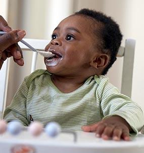 Closeup of a baby being fed by a spoon.